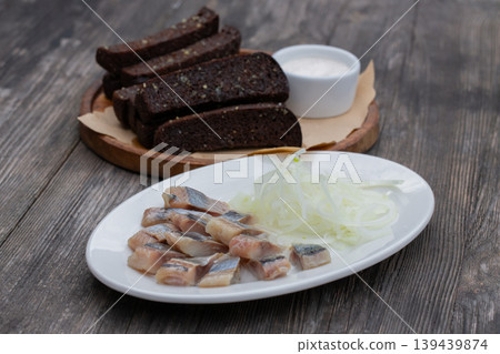 Pieces of salted herring with onions and garlic croutons. Pieces of salted herring with onions and garlic croutons. 139439874
