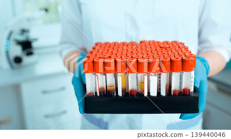 Laboratory scientist holding blood samples in a test tube rack. Blood research 139440046