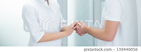A healthcare provider offers comfort and reassurance to a patient through a supportive handshake in a medical clinic setting A healthcare provider offers comfort and reassurance to a patient through a supportive handshake in a medical clinic setting 139440056