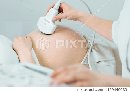 Pregnant woman having sonogram at clinic. Pregnancy ultrasound scan, stomach close-up Pregnant woman having sonogram at clinic. Pregnancy ultrasound scan, stomach close-up 139440083
