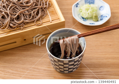 Dip the noodles in the soba dipping sauce. Dip the noodles in the soba dipping sauce. 139440491