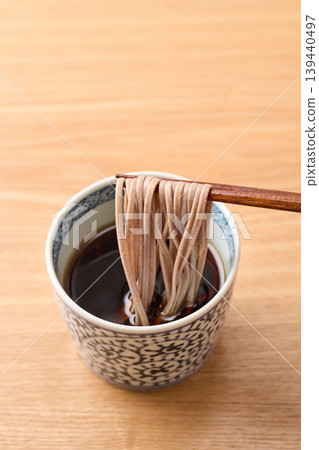 Dip the noodles in the soba dipping sauce. Dip the noodles in the soba dipping sauce. 139440497