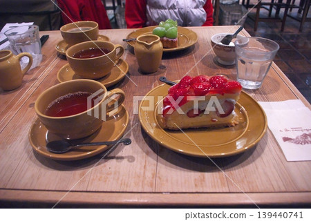 木桌上擺放著茶、草莓塔和麝香葡萄塔。 木桌上擺放著茶、草莓塔和麝香葡萄塔。 139440741