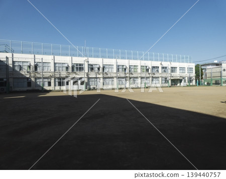 學校建築和寬敞的操場矗立在藍天之下。 139440757