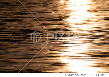Water surface shining in the setting sun 139441043