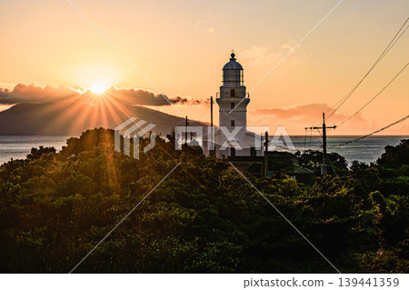 夕陽西下,映照著屋久島海灘上矗立的白色燈塔。 夕陽西下,映照著屋久島海灘上矗立的白色燈塔。 139441359