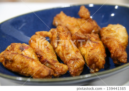 Deep-fried chicken wings served on a plate Deep-fried chicken wings served on a plate 139441385
