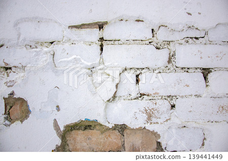 Texture wall of bricks shows visible cracks and peeling sections where paint has come off. This is seen in a building interior during the day. Texture wall of bricks shows visible cracks and peeling sections where paint has come off. This is seen in a building interior during the day. 139441449