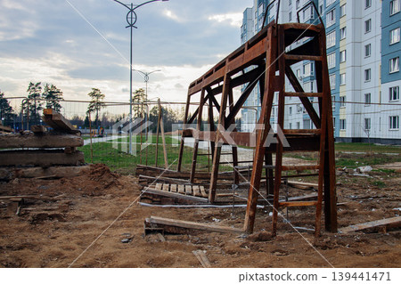 Construction site with old rusty metal structure and new apartment building Construction site with old rusty metal structure and new apartment building 139441471