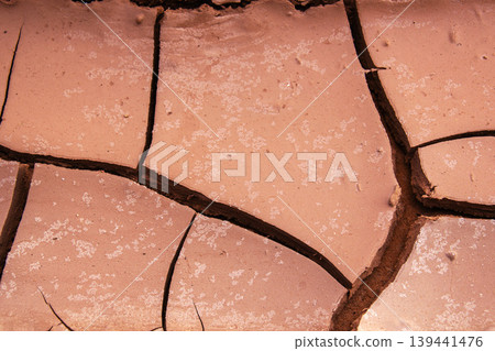 Close-up abstract texture of cracked dry earth with fine salt crystals scattered Close-up abstract texture of cracked dry earth with fine salt crystals scattered 139441476