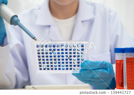 Scientist with cell culture in sample micro plate for research in science laboratory. 139441727