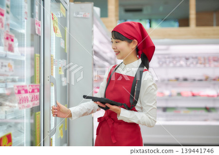 一位年輕女子正在使用平板電腦管理產品。 139441746