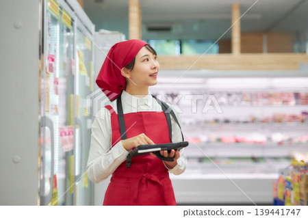 一位年輕女子正在使用平板電腦管理產品。 139441747