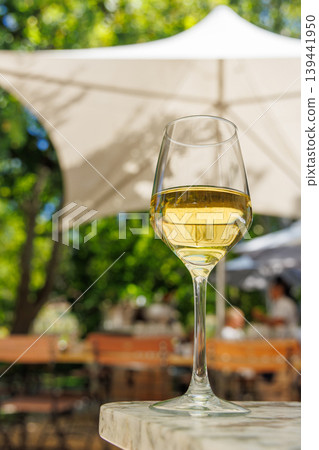 Glass of white wine on sunny terrace Glass of white wine on sunny terrace 139441950