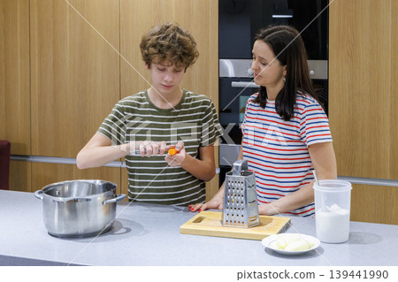 Mother teaching son cooking at home Mother teaching son cooking at home 139441990