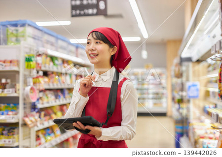 一位年輕女子正在使用平板電腦管理產品。 139442026