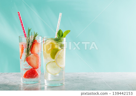 Two fresh non alcoholic drinks with strawberry and lemon on blue background 139442153