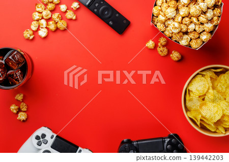 Popcorn, cola and gamepad on red background Popcorn, cola and gamepad on red background 139442203