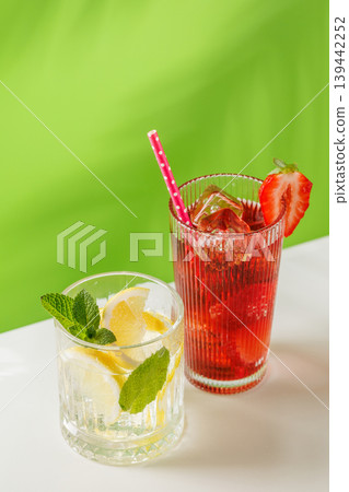 Healthy non alcoholic drinks with strawberry and lemon on green background Healthy non alcoholic drinks with strawberry and lemon on green background 139442252