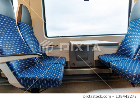 Interior of a deutsche bahn regional train carriage with empty blue seats and a table by the window. Interior of a deutsche bahn regional train carriage with empty blue seats and a table by the window. 139442272