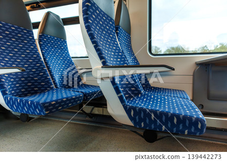 Interior of a deutsche bahn regional train carriage with empty blue seats and a table by the window. Interior of a deutsche bahn regional train carriage with empty blue seats and a table by the window. 139442273
