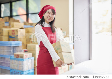 一位年輕女子在後屋使用平板電腦管理庫存。 139442282