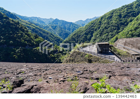 Beyond the rocky outcrop, a mountain covered in fresh greenery and an observation deck. Beyond the rocky outcrop, a mountain covered in fresh greenery and an observation deck. 139442463
