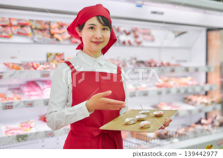 A young woman working at a supermarket's sample counter A young woman working at a supermarket's sample counter 139442977