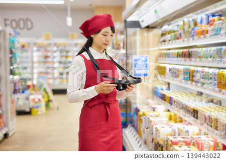 一位年輕女子正在使用平板電腦管理產品。 139443022