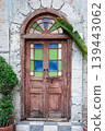 Old wooden door with green plant in pot on stone wall background. 139443062