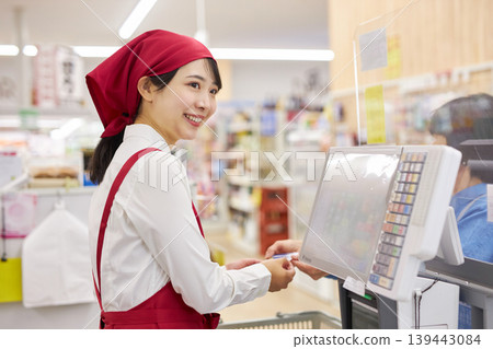 一位在超市收銀台工作的年輕女子 一位在超市收銀台工作的年輕女子 139443084
