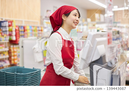 A young woman working at the checkout counter of a supermarket A young woman working at the checkout counter of a supermarket 139443087