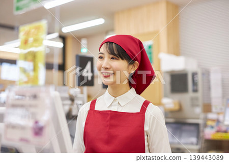 A young woman working at the checkout counter of a supermarket A young woman working at the checkout counter of a supermarket 139443089
