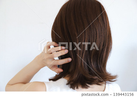 Back view of a woman touching her hair Back view of a woman touching her hair 139443156