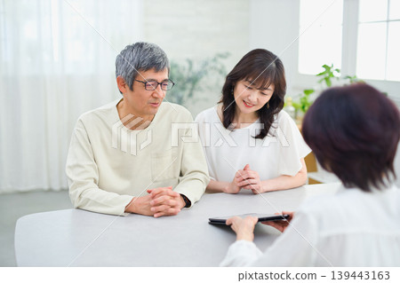 一位女銷售員正在向一對夫婦講解如何使用平板電腦 139443163