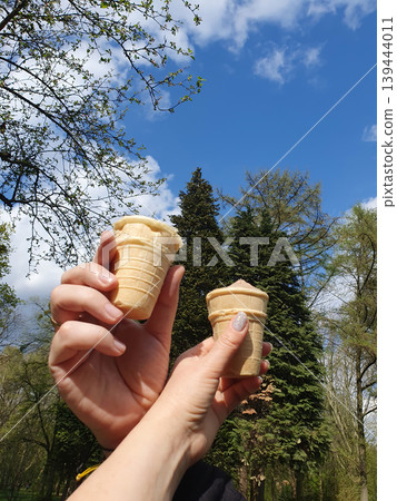 Two Hands Holding Broken Ice Cream Cones in Sunny Park Two Hands Holding Broken Ice Cream Cones in Sunny Park 139444011
