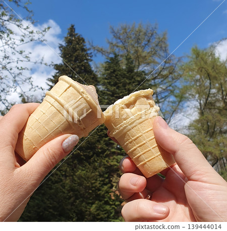 Two Hands Holding Broken Ice Cream Cones in Sunny Park Two Hands Holding Broken Ice Cream Cones in Sunny Park 139444014
