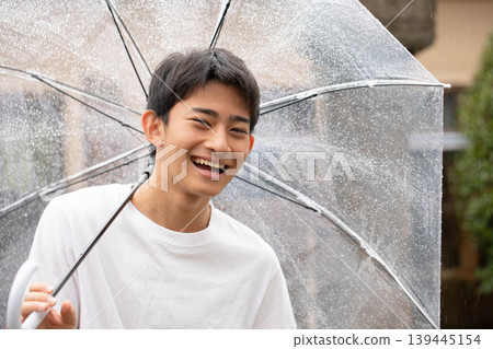 A smiling boy holding an umbrella A smiling boy holding an umbrella 139445154