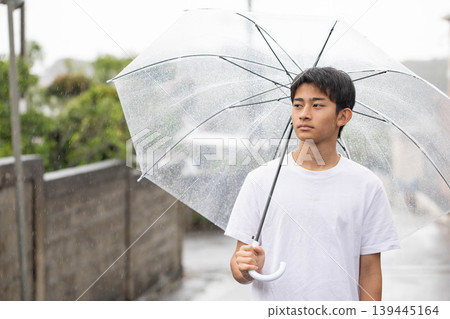 A man pointing a parasol 139445164
