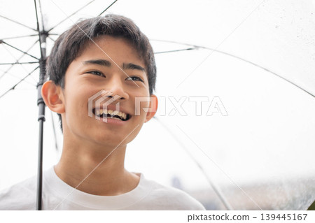 A smiling boy holding an umbrella A smiling boy holding an umbrella 139445167