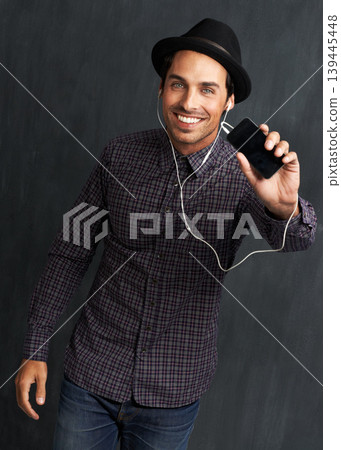 Fashion, music and portrait of man on gray background with trendy style, clothes and casual outfit. Smile, handsome and face of person with cellphone for listening to audio, radio and song playlist Fashion, music and portrait of man on gray background with trendy style, clothes and casual outfit. Smile, handsome and face of person with cellphone for listening to audio, radio and song playlist 139445448