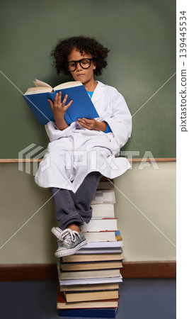 Child, classroom and reading books for school, science learning and physics knowledge on chalkboard and stack. Smart kid or african student in glasses with library resources and textbook for language 139445534