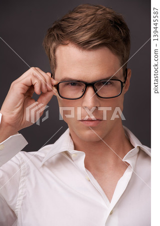Serious, man and confident portrait with glasses, fashion or choice in eyewear on dark background of studio. Check, optometry and geek with spectacles, style and person with prescription lenses Serious, man and confident portrait with glasses, fashion or choice in eyewear on dark background of studio. Check, optometry and geek with spectacles, style and person with prescription lenses 139445587