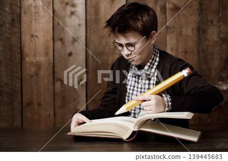 Education, book and young child writing information, youth development study or problem solving homework solution. stationery, textbook and scholarship kid, boy or student thinking of academic answer 139445683