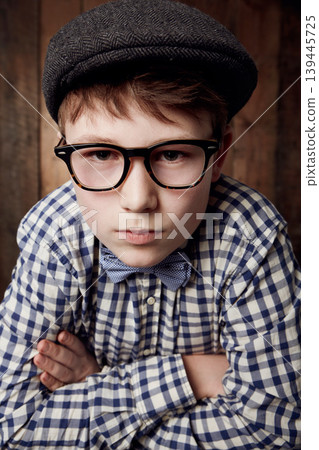 Portrait, glasses and serious kid with arms crossed for fashion, retro or vintage. Confident face, nerd and young boy child in hat, geek in stylish eyewear and trendy casual clothes in New Zealand Portrait, glasses and serious kid with arms crossed for fashion, retro or vintage. Confident face, nerd and young boy child in hat, geek in stylish eyewear and trendy casual clothes in New Zealand 139445725