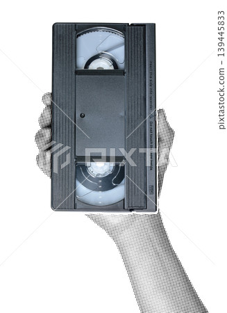Hand holding a VHS video cassette isolated on transparent background with vintage newspaper print texture. Concept of retro media, analog video technology and nostalgic communication Hand holding a VHS video cassette isolated on transparent background with vintage newspaper print texture. Concept of retro media, analog video technology and nostalgic communication 139445833