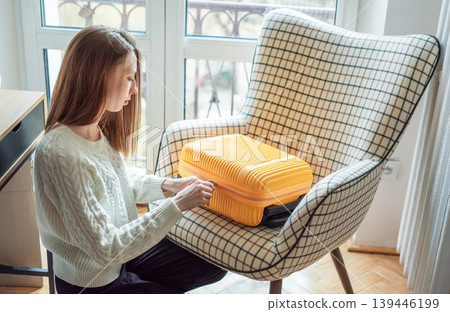 Woman packing suitcase before travel with golden retriever Woman packing suitcase before travel with golden retriever 139446199