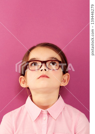Glasses, child and looking up with thinking geek and modern fashion in a studio with serious face. Kid, eyewear and sight with outfit and nerd with accessory and pink background with confidence Glasses, child and looking up with thinking geek and modern fashion in a studio with serious face. Kid, eyewear and sight with outfit and nerd with accessory and pink background with confidence 139446279