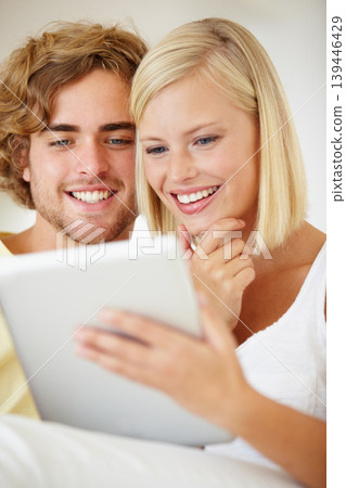 Smile, tablet and young couple on sofa browsing on social media or internet at apartment. Happy, digital technology and man and woman from Australia relax and scroll on website in living room at home 139446429