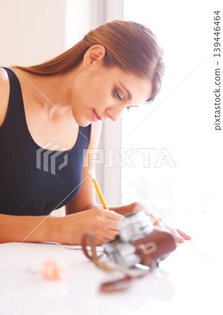 Woman, writing or photographer by retro camera on table, thought or communication for courier envelope in home. Young person, message or notepad for idea, paper or send letter to post office in house Woman, writing or photographer by retro camera on table, thought or communication for courier envelope in home. Young person, message or notepad for idea, paper or send letter to post office in house 139446464